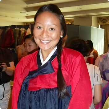 A Korean adoptee smiles in a Hanbok on a birthland tour.