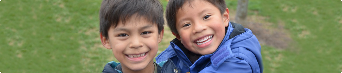 Brothers adopted from Guatemala hug in the park.