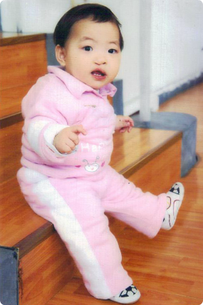 The referral picture of her daughter, sitting on a riser in a pink jumpsuit.