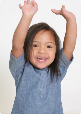A picture of Kayella, smiling with her arms in the air.