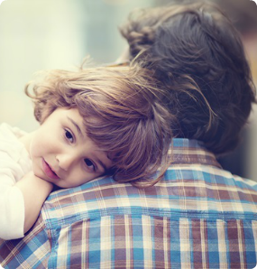A daughter cuddles into her father's shoulder.