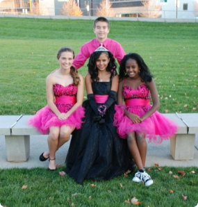 Luz, all dressed up for her Quincanera in a black ball gown with pink sash, surrounded by her siblings who are all wearing hot pink.