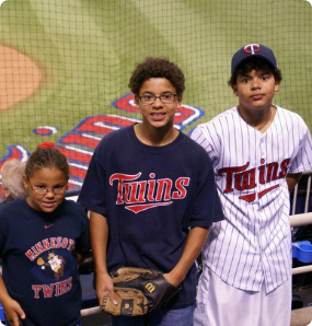 Kevin's kids at a Twins game a couple of years after he adopted them as a single dad from Brazil.