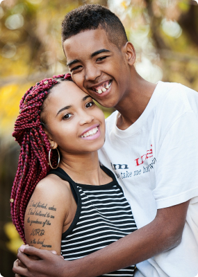 A picture of Promise and Omari smiling and hugging. They currently wait in Minnesota foster care.