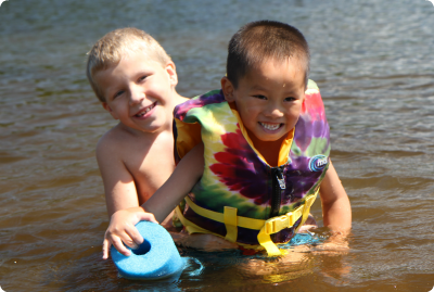Two brothers, one adopted from China through Children's Home, play in the water.