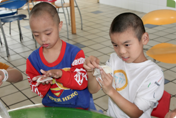 Two boys who wait for adoptive families make dumplings with Connect for Kids volunteers.