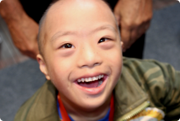 A picture of KC, who waits in China, smiling brightly at the camera.