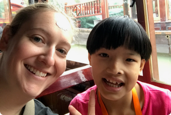 A photo of Kang Kang, who waits for an adoptive family in China, with an orphanage volunteer from Connect for Kids.