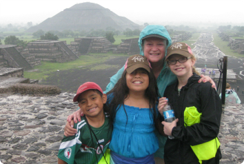 An adoptive mother poses with her kids, including her Mexican-heritage daughter, as they travel in Mexico to visit birth family and explore birth culture.