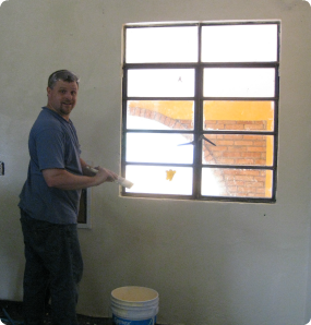 Dani's father painting the orphanage walls while visiting Mexico on a heritage trip.