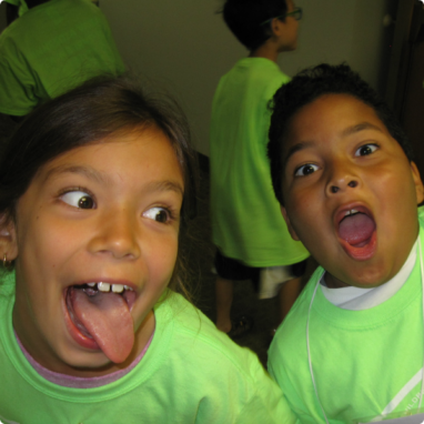 Two 9-year-old adoptees make funny faces at the camera at Adoption Day Camp.