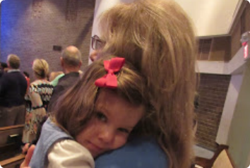 A picture of Sonya's daughter in her grandmother's arms at church. She looks content.