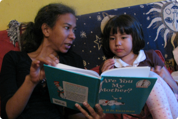 A picture of a mother reading "Are You My Mother" to her daughter.