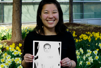 Dana, an adult Korean adoptee, smiles as she holds her referral photo for our book that celebrates the past, present and future of adoptees.