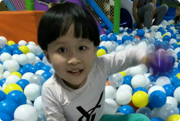 A picture of GA smiling in a ball pit.
