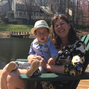 Jennifer with her son Jack on her lap in an Adirondack chair on her first Mother's Day.