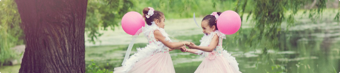 Two sisters adopted from foster care spin in circles with balloons.