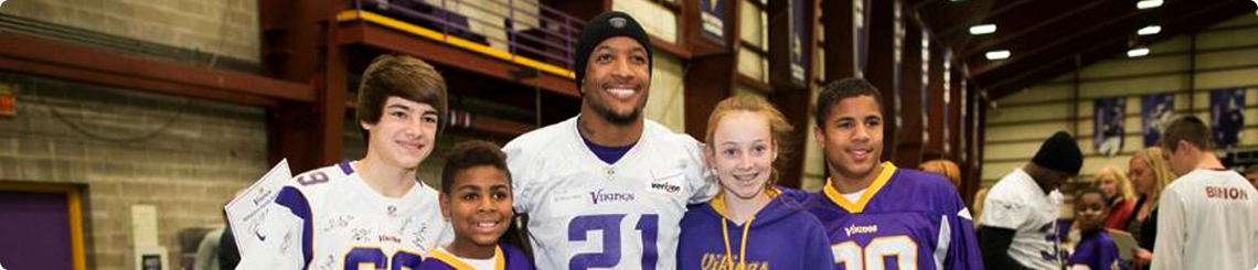 Children from adoptive families pose with a Vikings player.