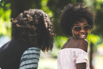 A teen girl smiles while looking back at her mother. She was adopted from foster care at 13.