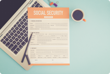 A flat design photo of a social security benefit application sitting next to a laptop and cup of coffee.
