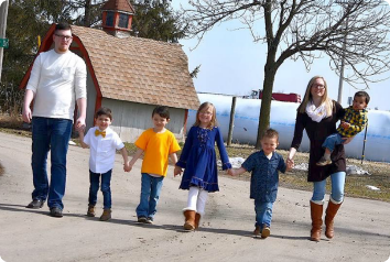 Miranda and Brian walk down a rural street with their five kids adopted from foster care.