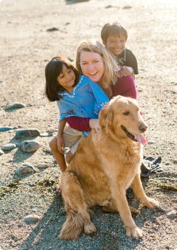 Courtney, a single mom, cuddles with her two kids adopted from India and their golden retriever.