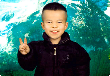 A 9 year old in Asia smiles holding the peace sign. He waits for adoption.