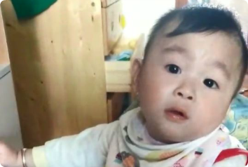 A toddler waiting in Asia for an adoptive family looks at the camera.