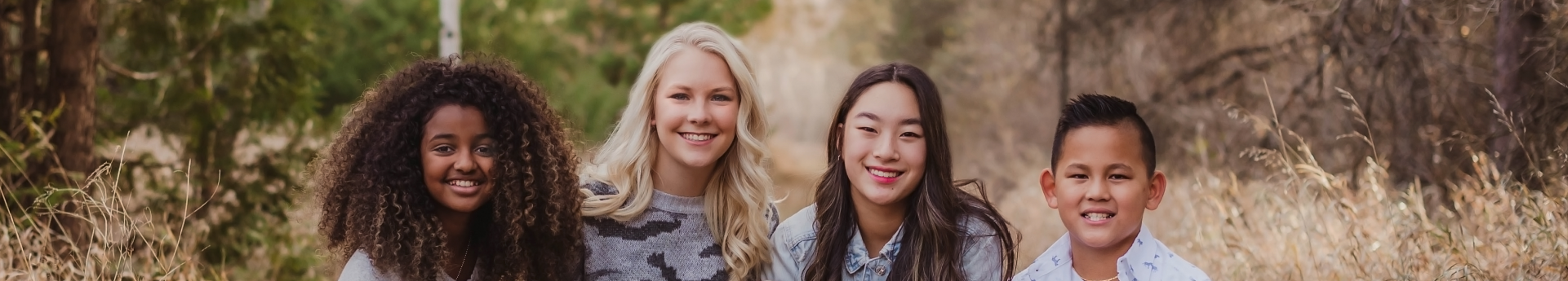Multiracial and multicultural teen siblings smile for family photo