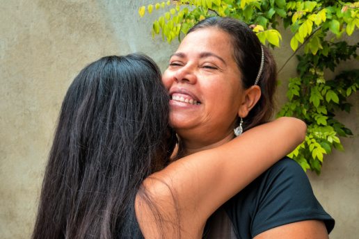 Colombian Mother and teen daughter hugging.