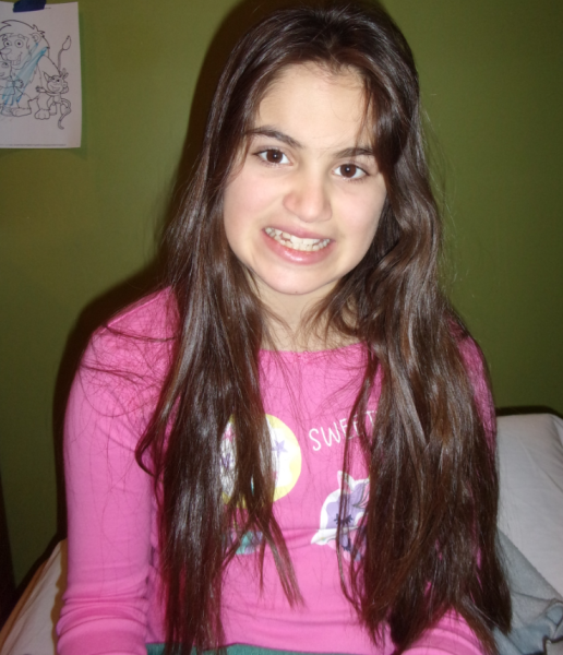 12-year-old girl with brown hair smiles in pink shirt