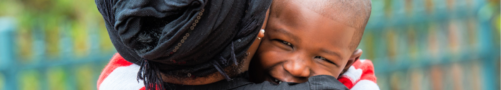 Woman from back hugging afro-Caribbean boy