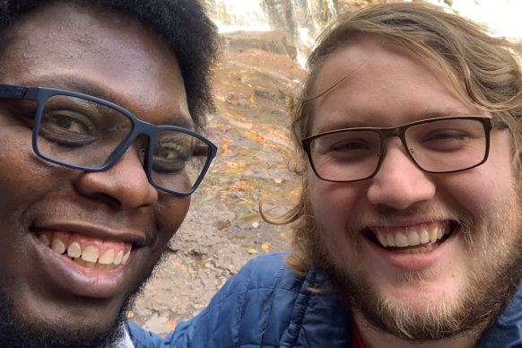 Male couple smiles outdoors