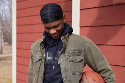 African American teen smiles with his basketball