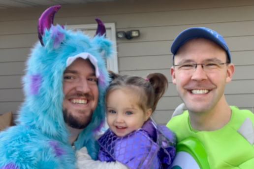 Happy family of three smiles in Halloween costumes