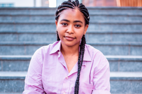 Portrait of African American teen girl with braids and purple shirt