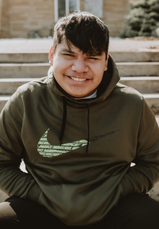 17-year-old boy smiles outside wearing hoodie