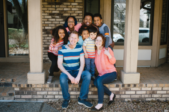 Happy multicultural family smiles on porch