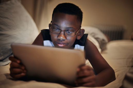 Child on laptop in bed