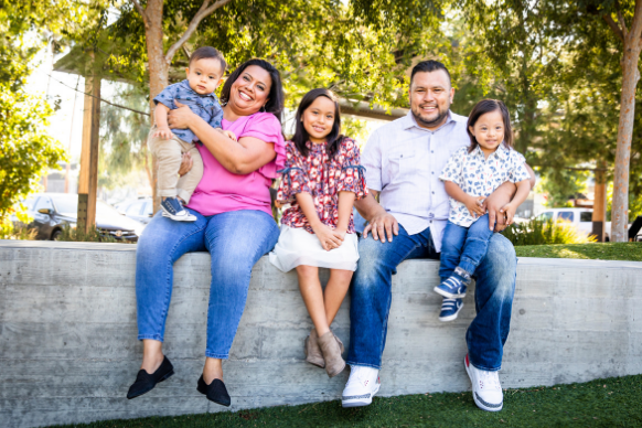 Latino family of five smiles for photo