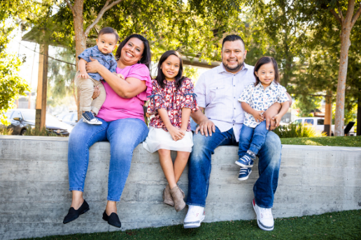 Latino family of five smiles outside
