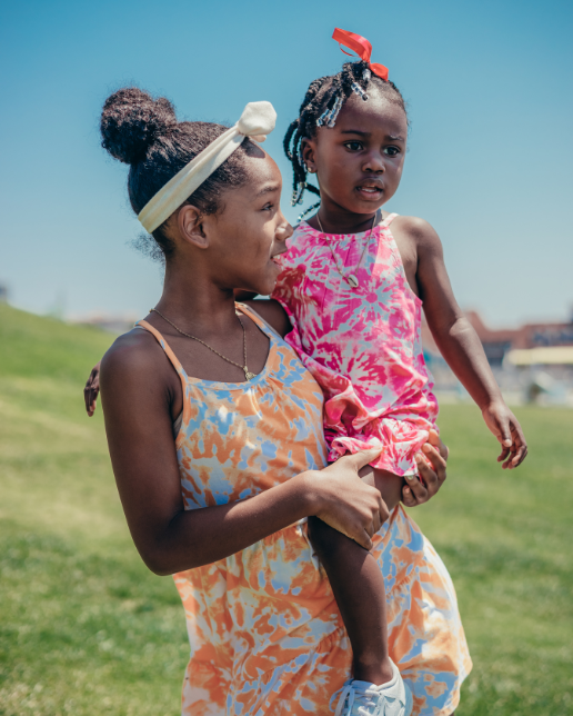Older girl holding younger girl