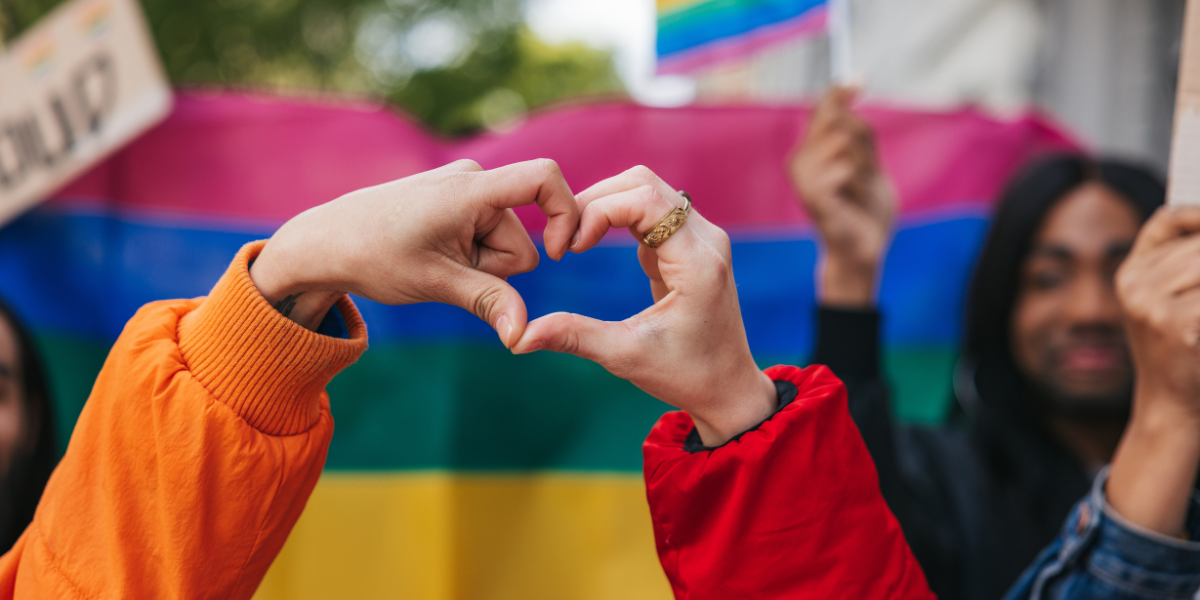 pride flag and hands making a heart