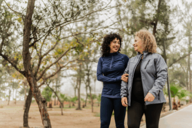 two women walking and talking in a park