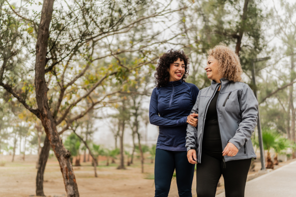 two women walking and talking in a park