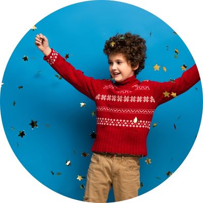 child in holiday sweater with confetti 