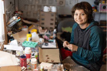 Jessie using creativity for a cause, making trinkets at their craft table