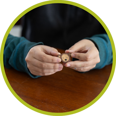 detail of Jessie holding a monkey magnet, using creativity for a cause