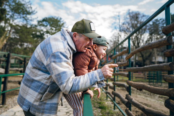 Grandfather and grandson looking at animals at a zoo