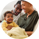 two men holding an infant